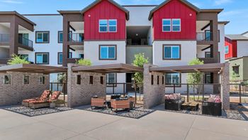 An outdoor patio with furniture in front of an apartment building